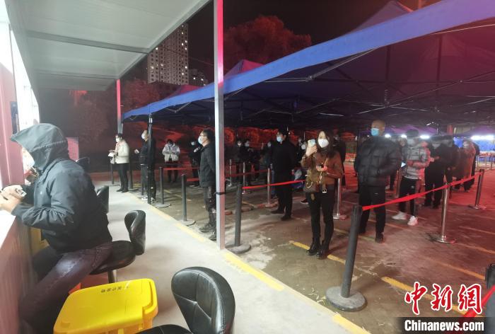 圖為核酸采集窗口前排隊(duì)等候的市民。　潘雨潔 攝
